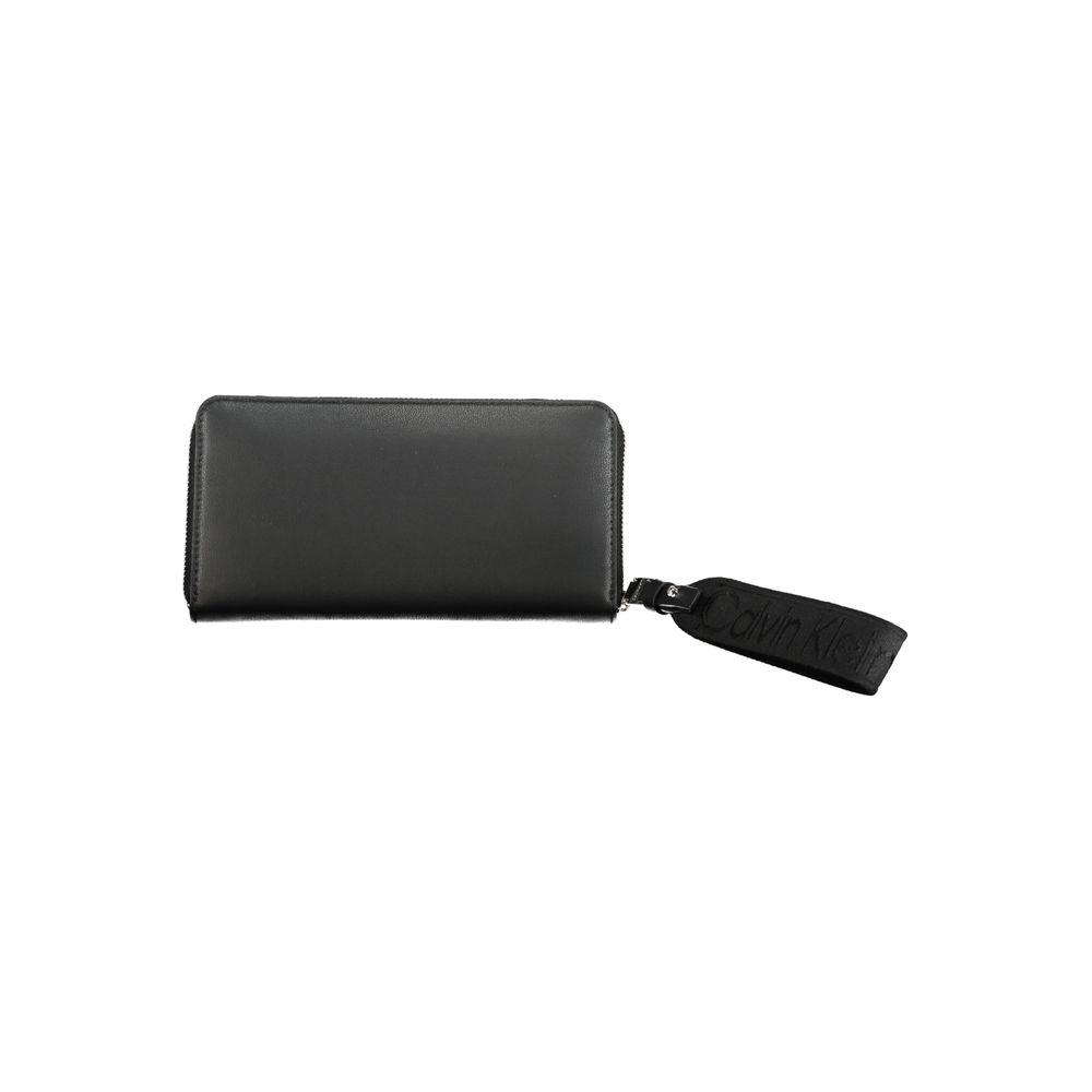 Calvin Klein black polyethylene wallet with zip closure, 5 compartments, coin purse, card slots, and removable pull.