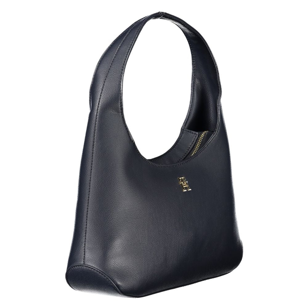 Elegant Tommy Hilfiger blue polyester handbag with shoulder handle, internal pocket, zip closure, and logo. Stylish accessory.