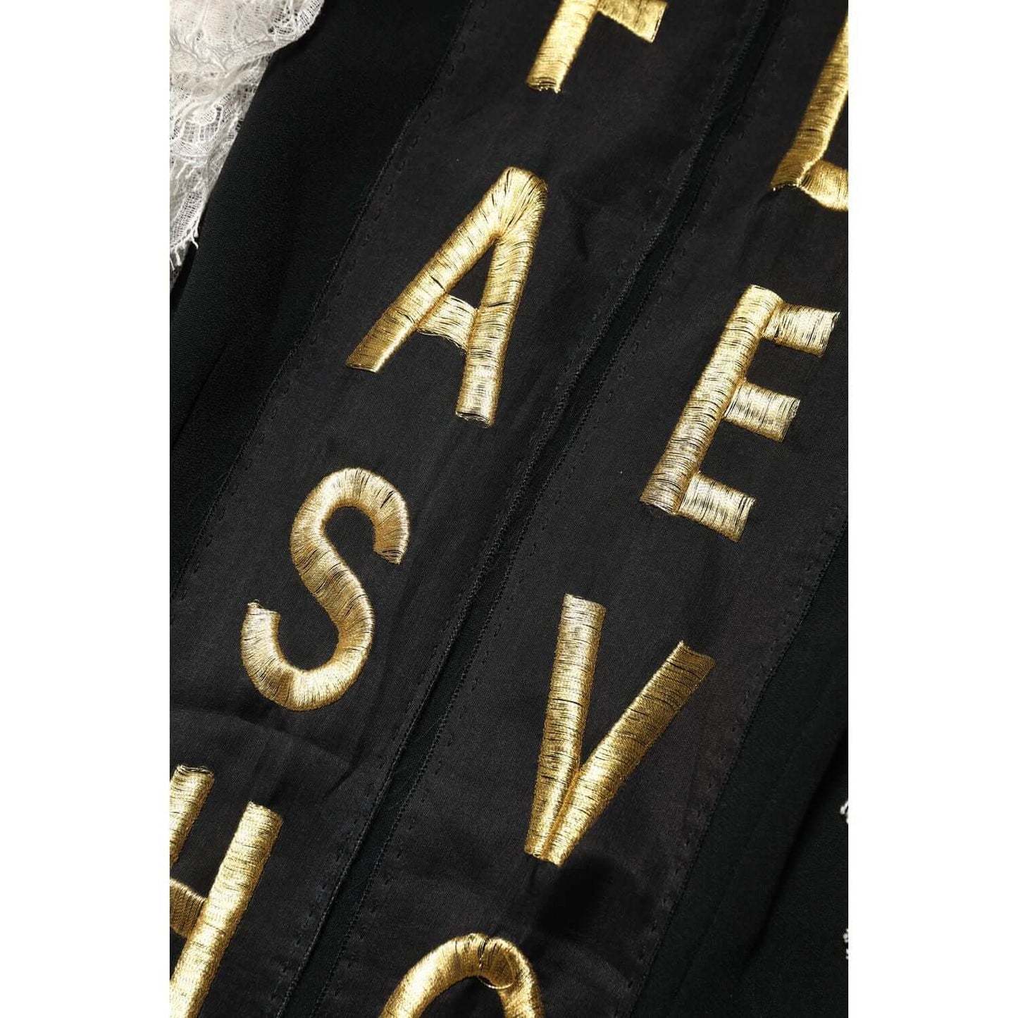 Close-up of Dolce & Gabbana's black mini dress with gold embellishments and lettering detail.