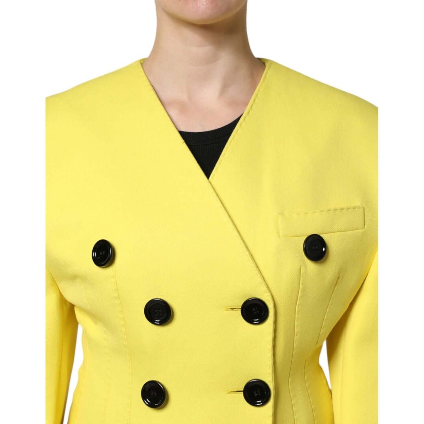 Dolce & Gabbana yellow double-breasted wool trench coat with black buttons, shown close-up of the front detailing.