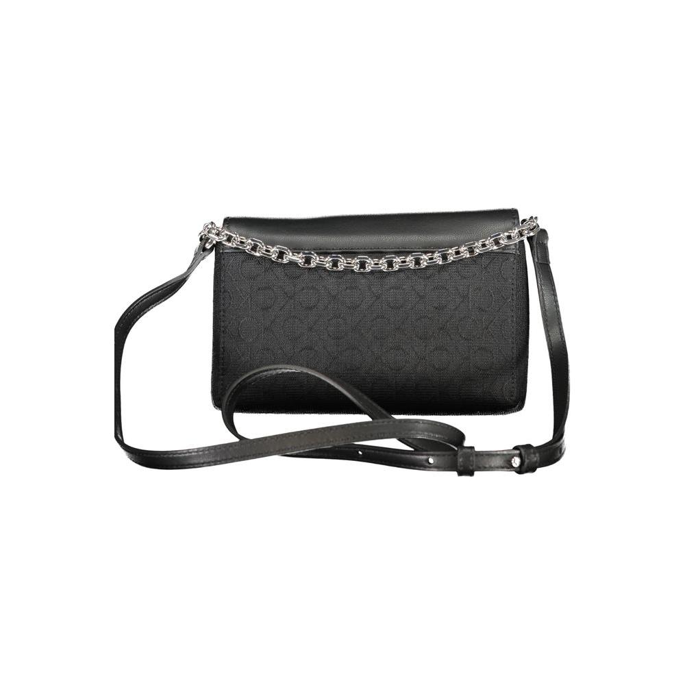 Calvin Klein black polyester handbag with chain handle, adjustable shoulder strap, two compartments, contrast details, and swivel closure.