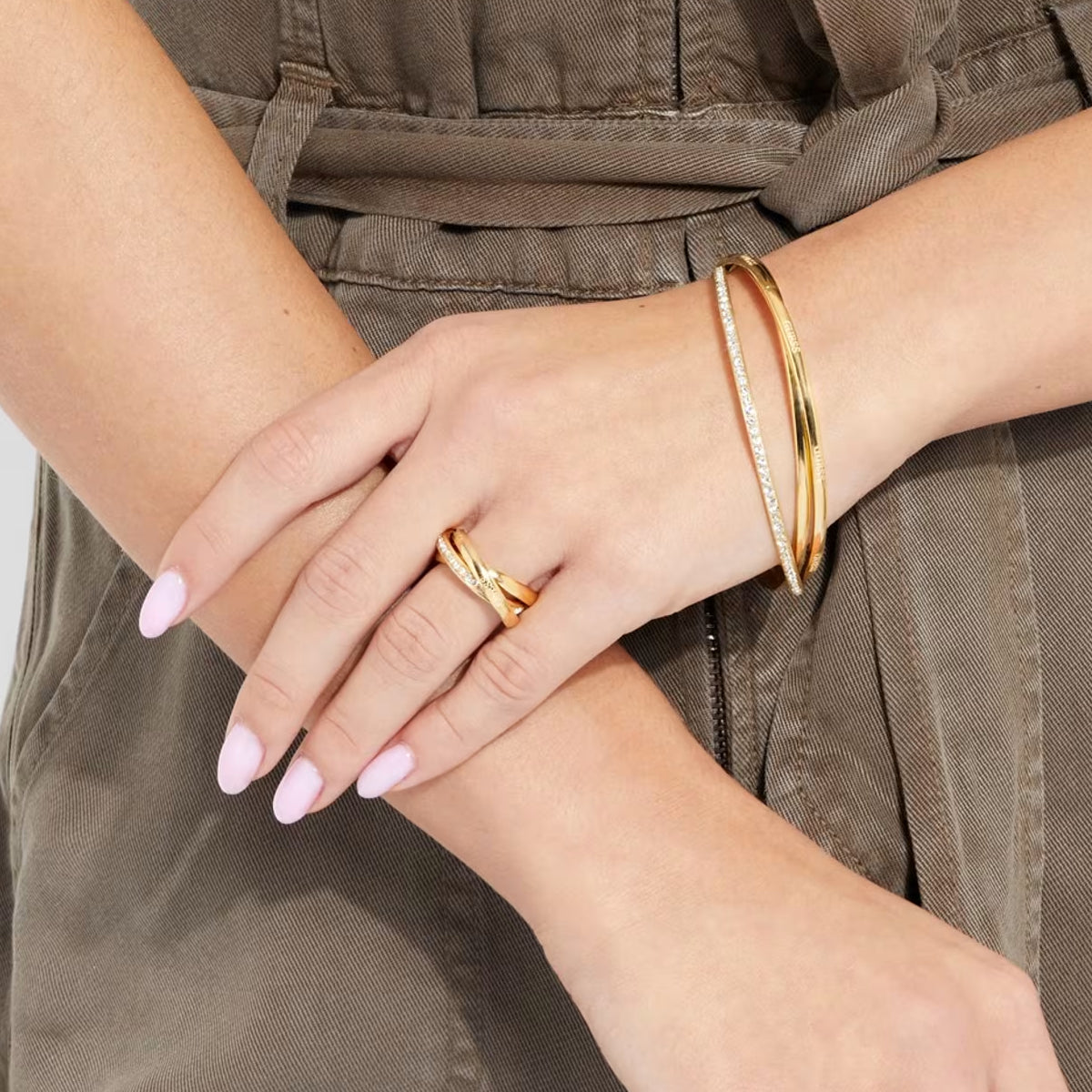 Elegant gold bracelet and ring set from GUESS JEWELS JEWELRY Mod. JUBR04067JWYG56 on woman's wrist and hand.