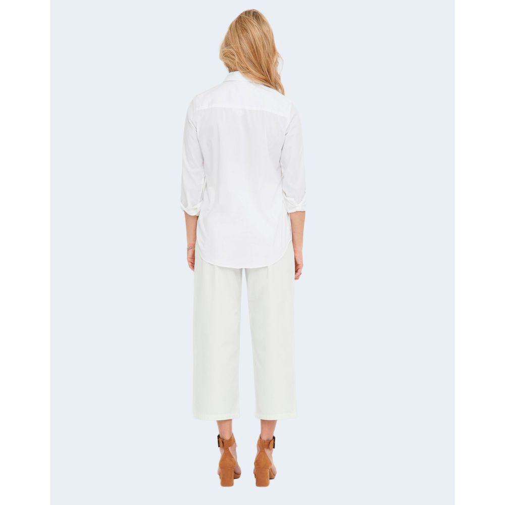 Back view of woman wearing Jacqueline De Yong white long-sleeve cotton shirt, styled with white pants and brown heels.