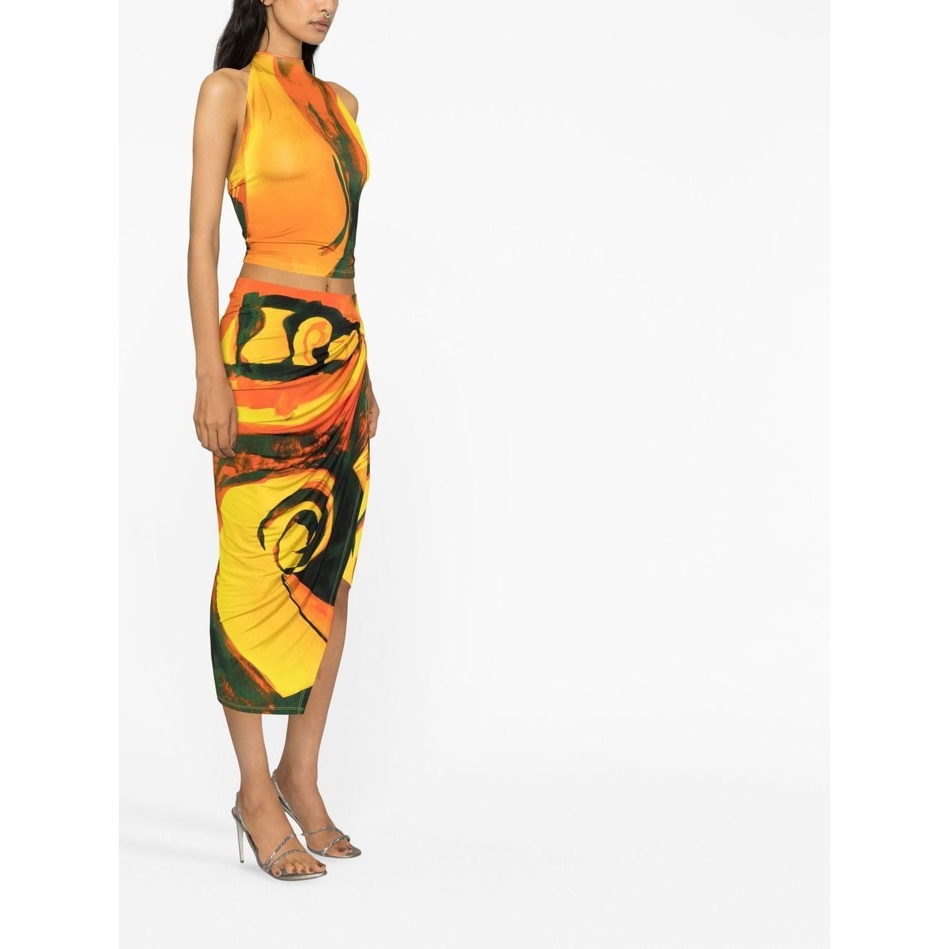 Model wearing Louisa Ballou multicolour abstract wrap skirt with asymmetric design and ring hardware, paired with matching top.
