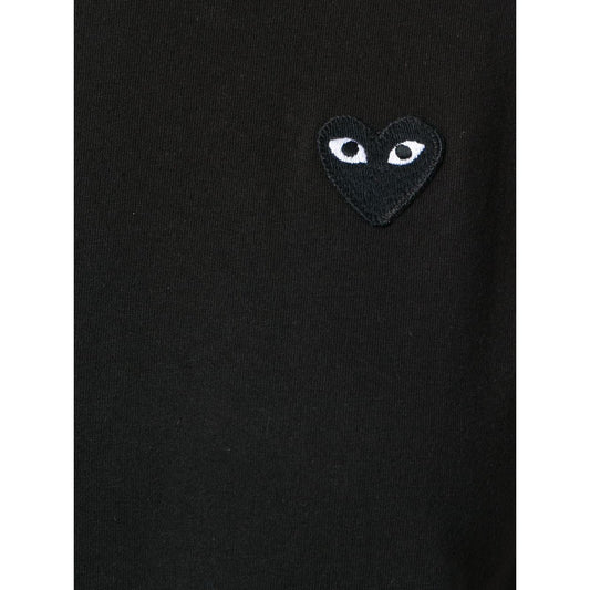Black Comme des Garcons T-shirt with almond-eyed heart logo on chest.