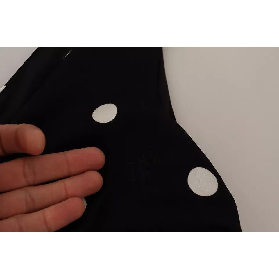 فستان دولتشي آند غابانا من الحرير الأسود المنقط بفتحة رقبة على شكل حرف V وقصّة ميدي