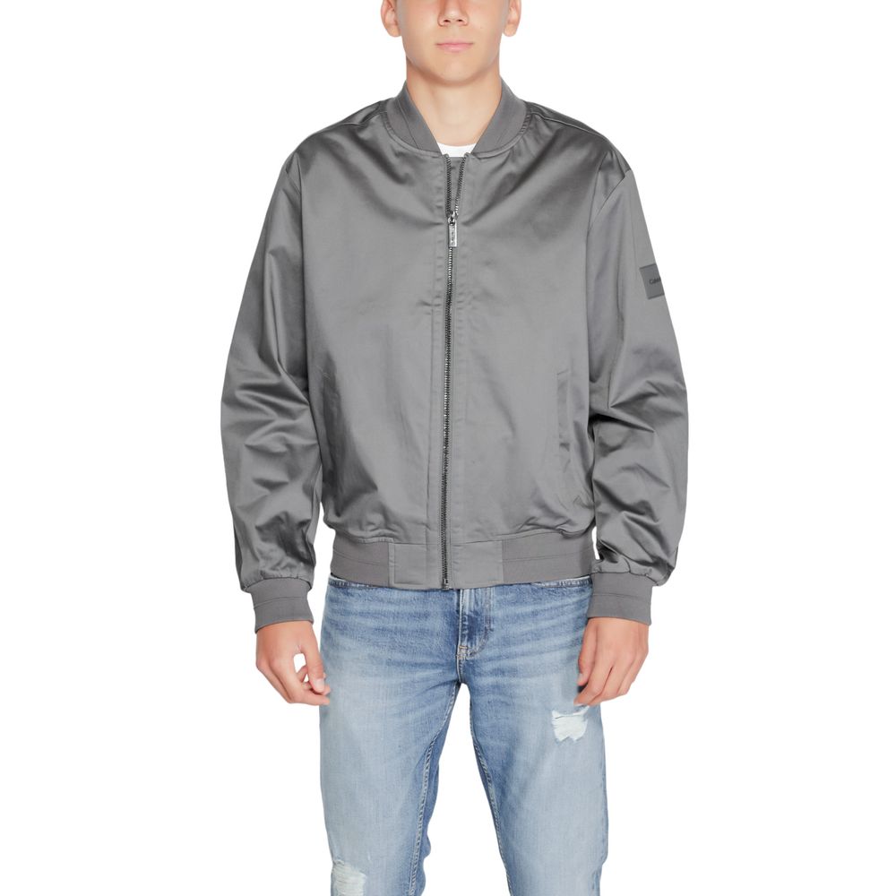 Man wearing Calvin Klein Gray Organic Cotton Bomber jacket standing against white background.