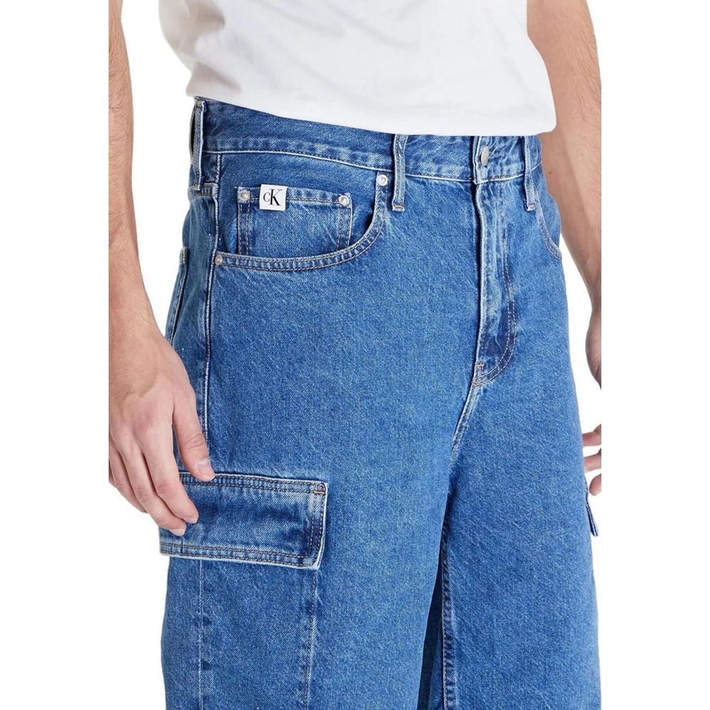 Model wearing Calvin Klein Jeans Blue Cotton Bermuda Shorts with flap side pockets, showcasing 90's loose fit style for a relaxed look.