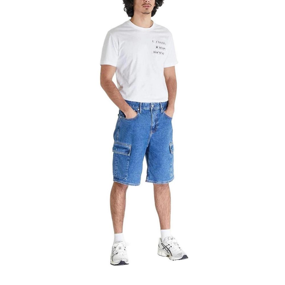 Man wearing Calvin Klein Jeans Blue Cotton Bermuda Shorts with white t-shirt and sneakers, showcasing a casual summer style.