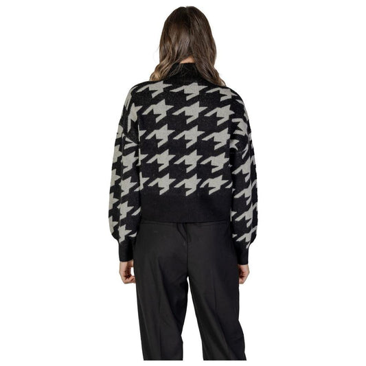 Back view of woman wearing Vero Moda black acrylic sweater with houndstooth pattern, part of the fall/winter women's knitwear collection.