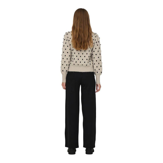 Back view of woman wearing Jacqueline De Yong beige polka dot polyester sweater, autumn/winter collection, paired with black pants.