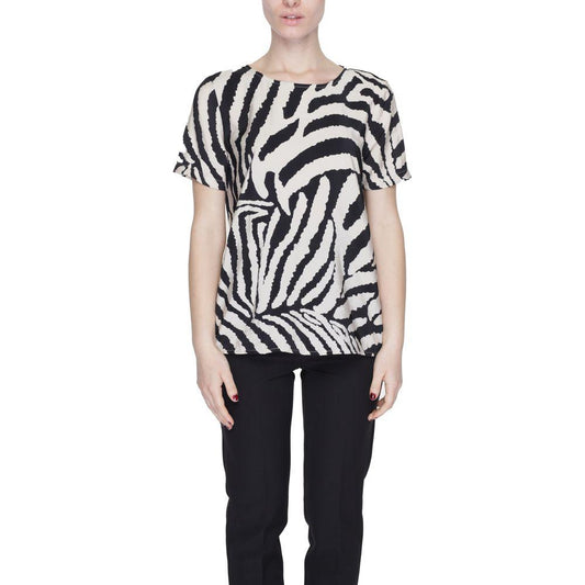 Woman wearing a zebra print short-sleeve top and black pants, showcasing a bold and stylish look