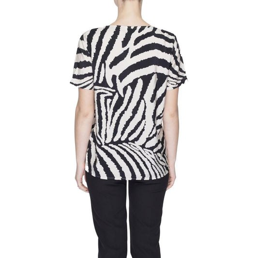 Back view of a woman wearing a zebra print short-sleeve top, paired with black pants, showcasing a casual outfit style.