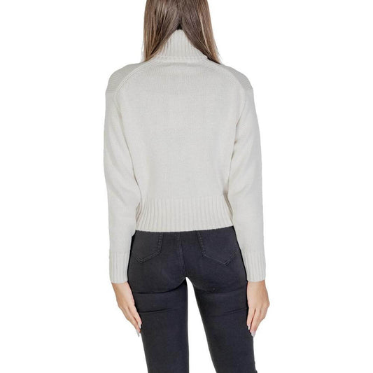 Back view of woman wearing Calvin Klein cream cotton sweater, fall/winter knitwear collection, showcasing ribbed hem and long sleeves.