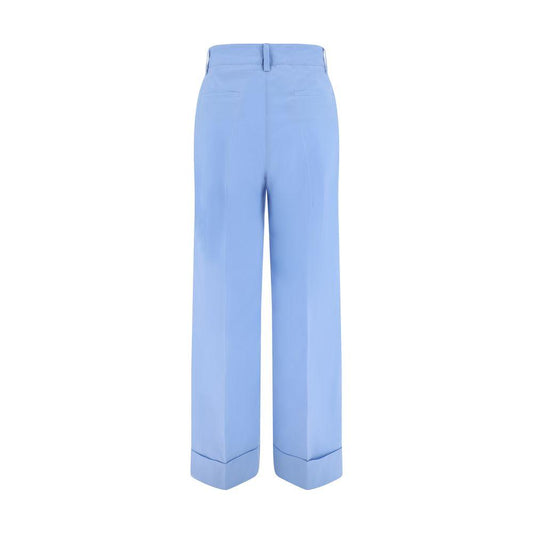 Back view of blue P.A.R.O.S.H. cotton pants with turned-up hem, button and zipper closure, side slash pockets, and back welt pockets.