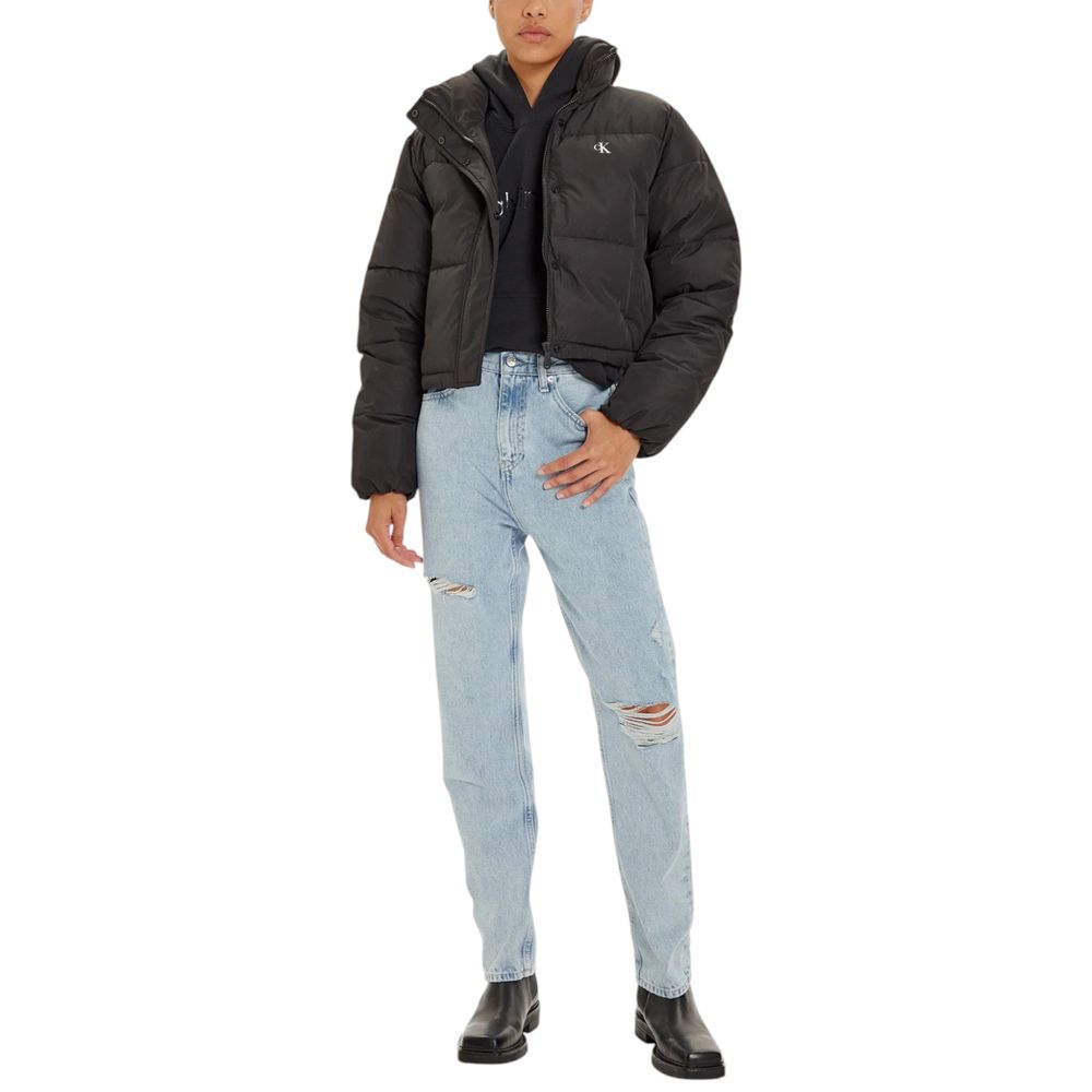 Model wearing Calvin Klein Jeans Black Polyester Jackets & Coat, cropped and stylish, paired with ripped jeans and boots.