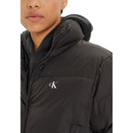 Close-up of woman wearing Calvin Klein Jeans Black Polyester Jackets & Coat, featuring a high collar and hood.
