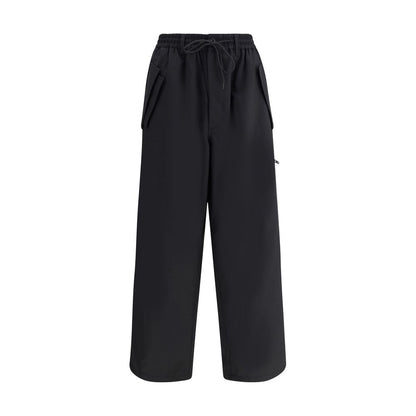 Y-3 Black Wool Casual Pants with elastic waistband and asymmetrical cuffs, showcasing urban style and functionality with multiple pockets.