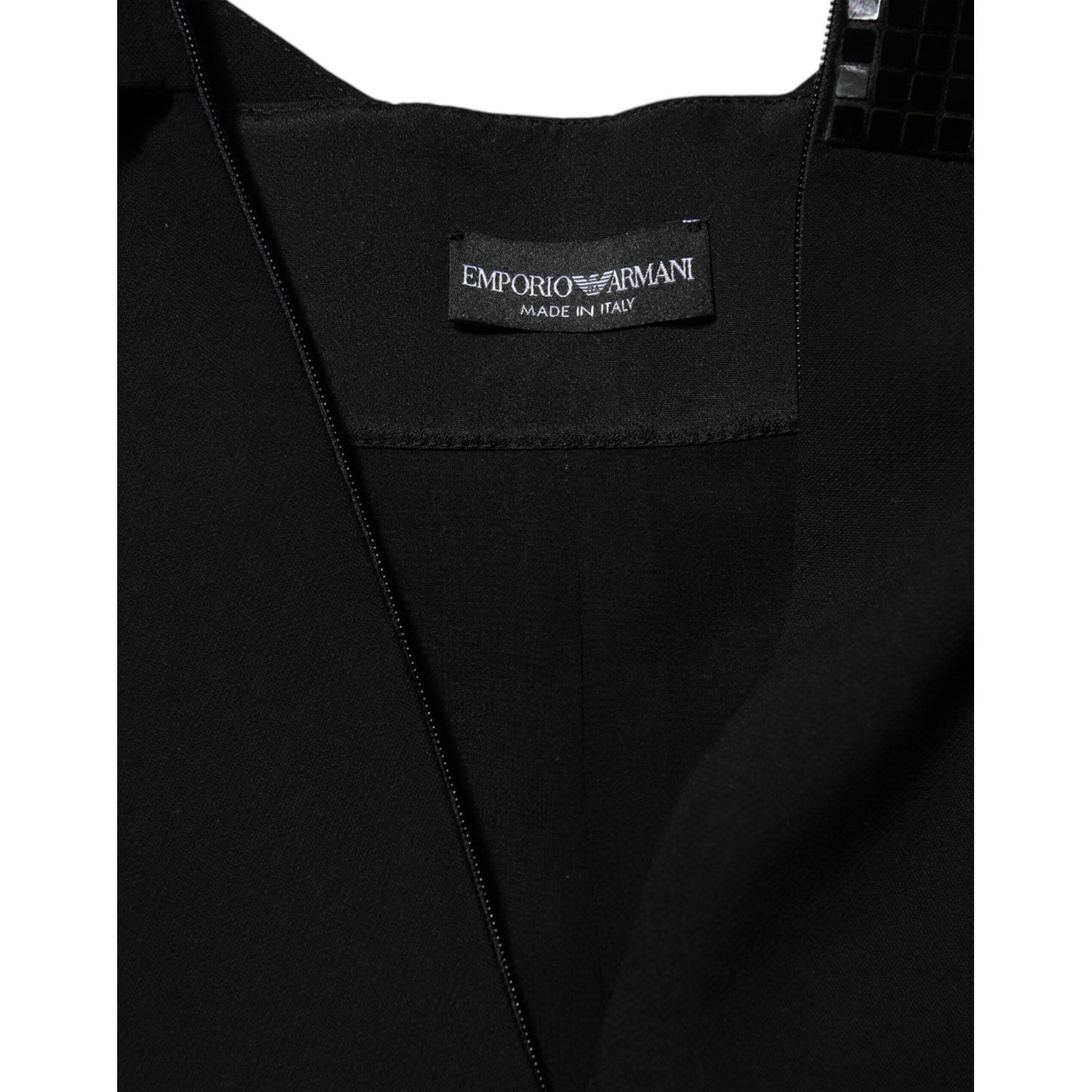 Close-up of label on Emporio Armani Black Sheer Sleeve Belted V-Neck Mini Dress, showcasing brand and quality details.