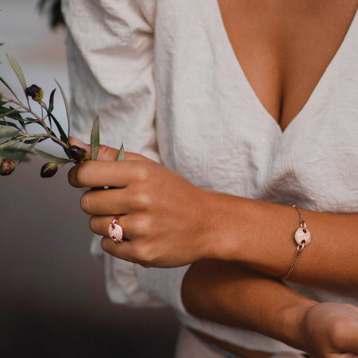 Woman wearing AN JEWELS JEWELRY Mod. AL.BJT01RC ring and bracelet, holding a branch elegantly.