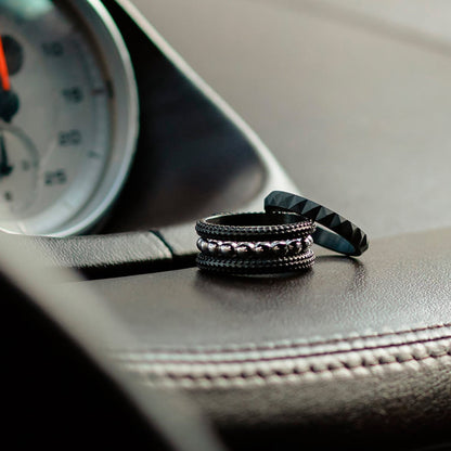 AN JEWELS JEWELRY Mod. AR.R2NS02BK-8 rings displayed on car dashboard, showcasing elegant black and silver design.
