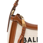 Close-up of Balmain B-Army canvas shoulder bag with beige canvas, brown leather trim, and zip fastening featuring the brand's logo.
