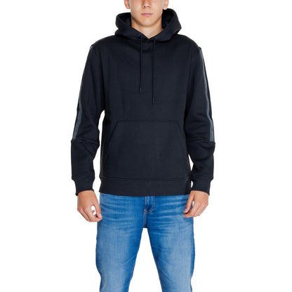 Model wearing a Calvin Klein Jeans Black Cotton Hoodie with drawstring hood and front pocket.