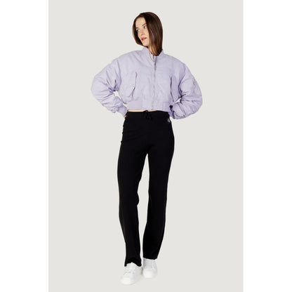 Model wearing Calvin Klein Jeans Purple Polyamide Bomber, cropped and oversized with front zip closure, styled with black pants.
