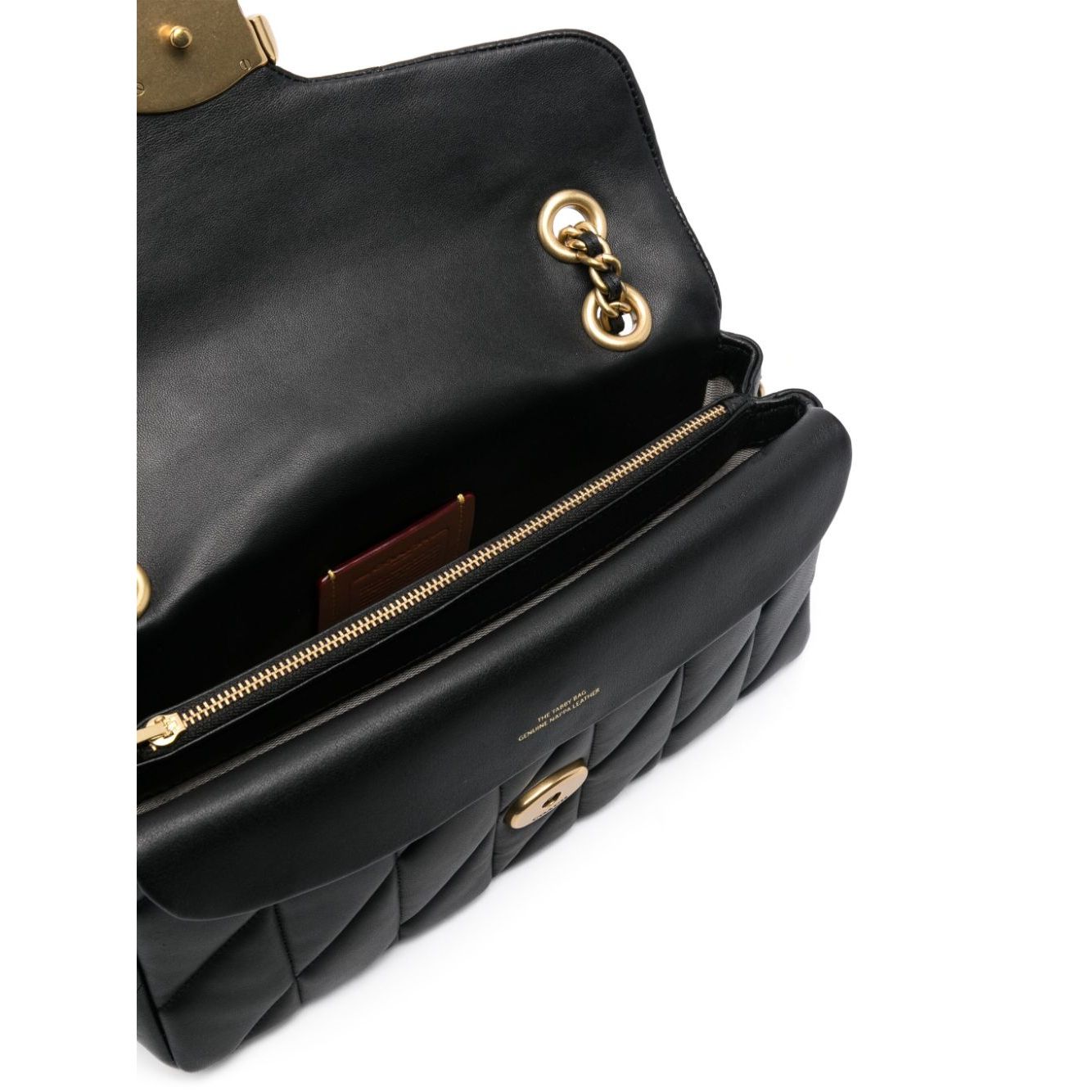 Open view of Coach Tabby shoulder bag in black quilted calf leather with gold-tone hardware, showcasing interior compartments and lining.