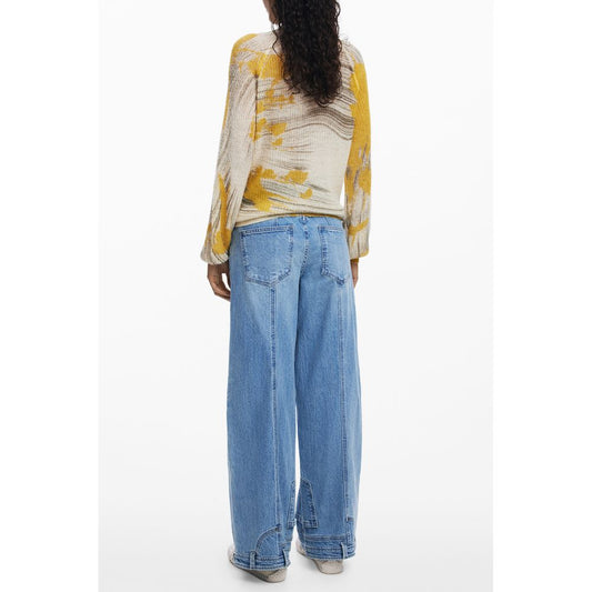 Back view of model wearing Desigual Yellow Wool Women Sweater with floral patterns, paired with blue wide-leg jeans, showcasing bold style.