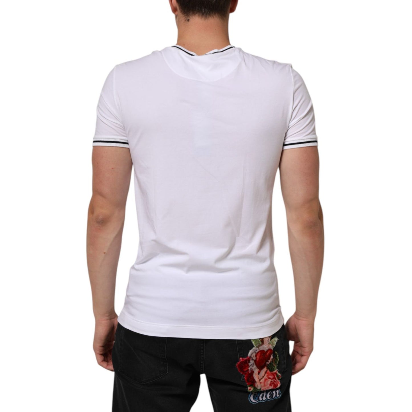Back view of model wearing Dolce & Gabbana White Short Sleeves Deep V-Neck Men T-shirt, featuring logo details and comfortable fit.