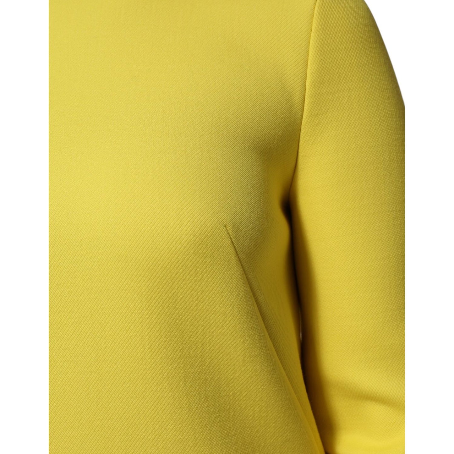 Close-up of Dolce & Gabbana Yellow Viscose Acetate Mini Long Sleeve Dress fabric and shoulder detail.