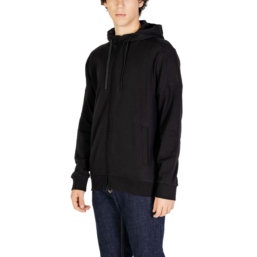 Man wearing EA7 Emporio Armani Black Cotton Hoodie with zip closure and adjustable hood for maximum comfort and warmth.