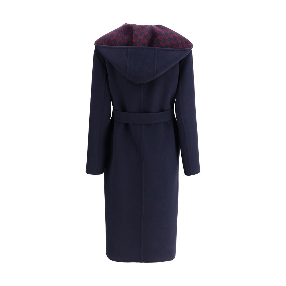 Gucci Blue Wool Coat with hood, removable sash, and Gucci monogram on inner panel, showcasing elegant and functional design.