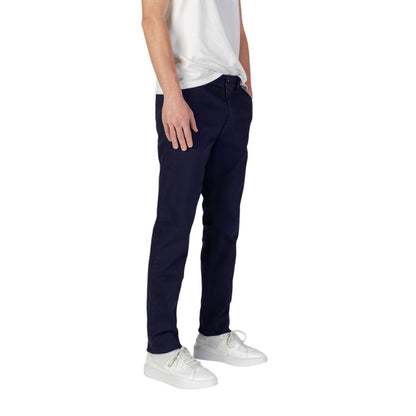 Man wearing Hugo Boss Blue Cotton Skinny Pants showcasing slim fit design with casual sneakers and white shirt.
