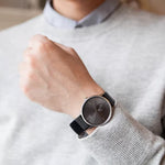 Gent's wrist wearing CALVIN KLEIN Mod. ACCENT wristwatch with leather strap and stainless steel case, showcasing elegant design.