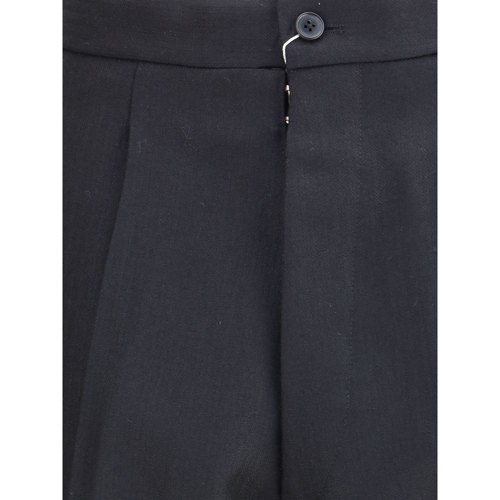 Close-up of Margiela Black Wool Dress Pants showcasing pleated design and button closure.