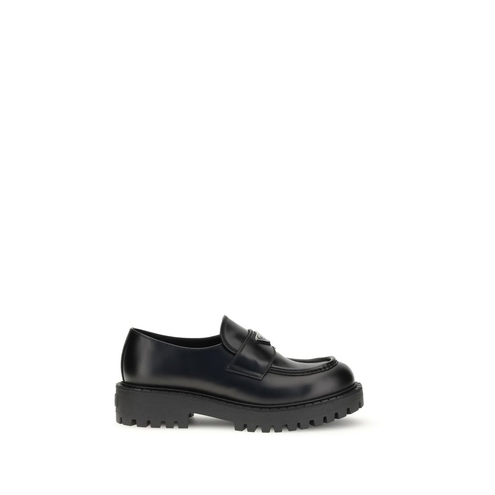Prada Black Calf Leather Bos Taurus Slip-On Loafers with enameled triangle symbol, rubber sole, and double welt design AW25.
