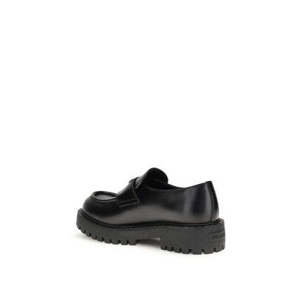 Prada Black Calf Leather Bos Taurus Slip-On Loafers with enameled triangle detail and rubber sole, showcasing AW25 fashion style.