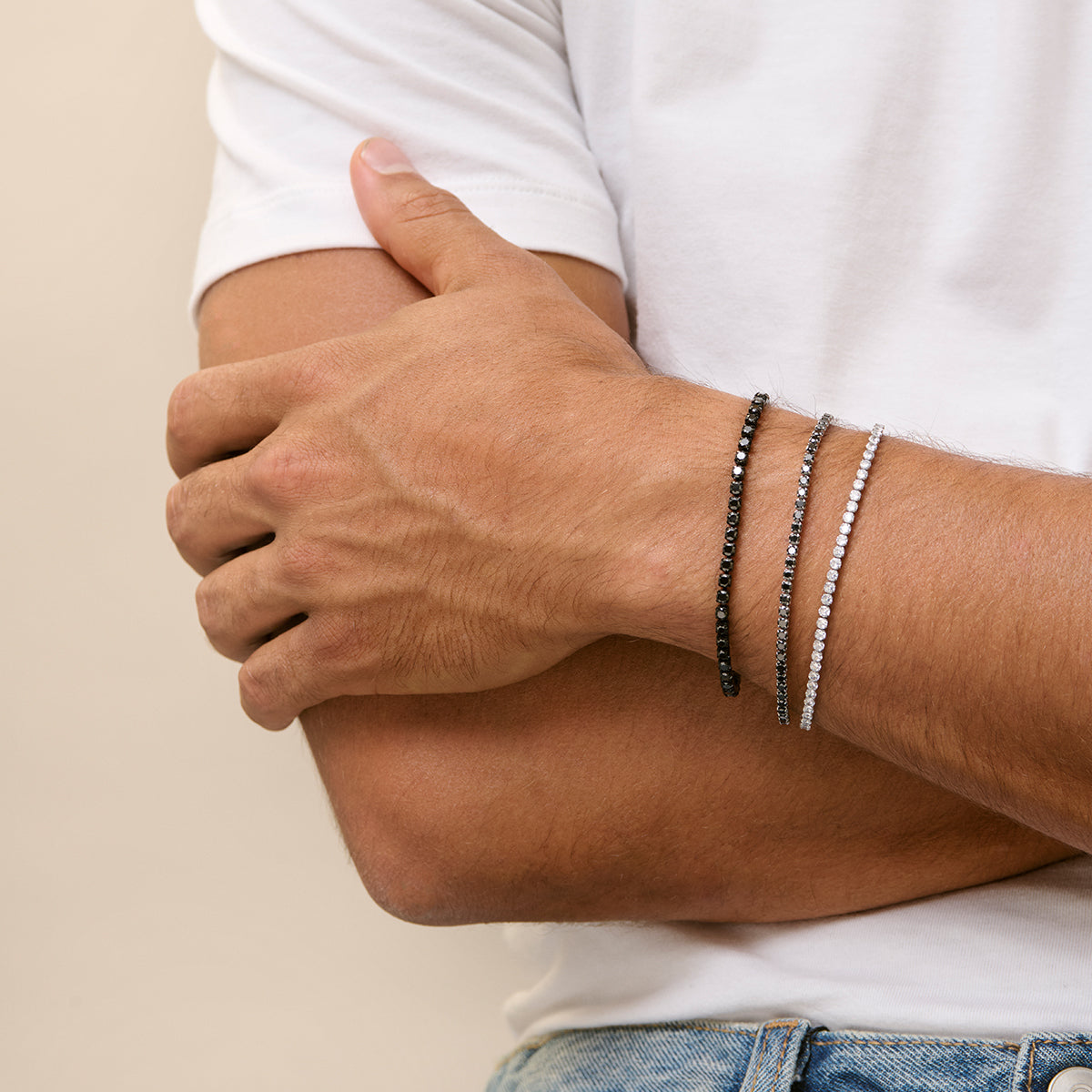 Stylish wrist jewelry featuring sleek black and silver bracelets on a man's arm, adding a touch of elegance to casual attire.
