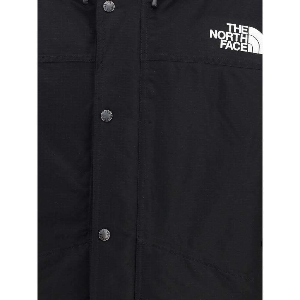 Close-up of The North Face Black Polyester Coat, featuring logo and button details for protection in harsh conditions.
