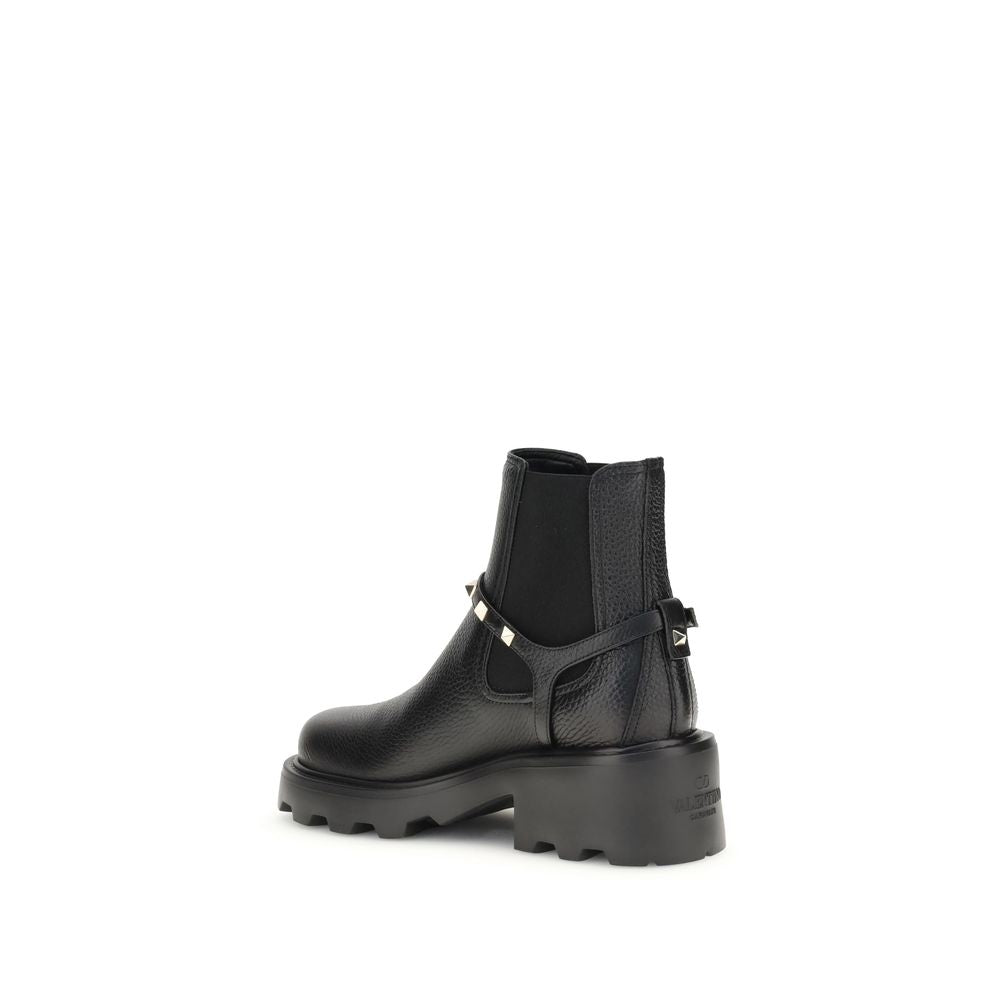 Valentino Garavani Black Calf Leather Bos Taurus Ankle Boots with metal studded strap and elastic insert for easy wear, side view